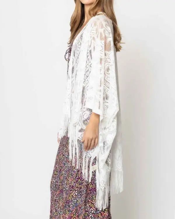 Beautiful lace kimono with fringes on the bottom. The pattern of lace is elegant and laser cut edges look gorgeous with fringes. Great for everyday outfits, beach cover-ups and more!One sizeDimensions: approximately 50 inches wide x 29 inches long100% Polyester Material Composition: 100% Polyester Bohemian Lace Beach Cover-up, Bohemian Lace Cover-up With Lace Trim, Lace Cover-up With Lace Trim For Vacation, Bohemian Lace Cover-up With Lace Patchwork, Lace Patchwork Beach Cover-up, Lace Cover-up With Lace Trim, Lace Beach Cover-up With Lace Trim, Bohemian Lace Cover-up For Summer, Open Front Lace Trim Cover-up For Festivals