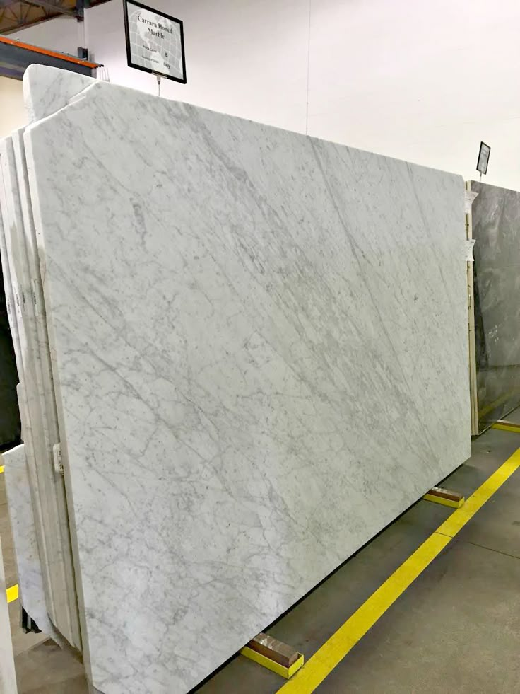 two large marble slabs sitting next to each other in a room with yellow lines on the floor