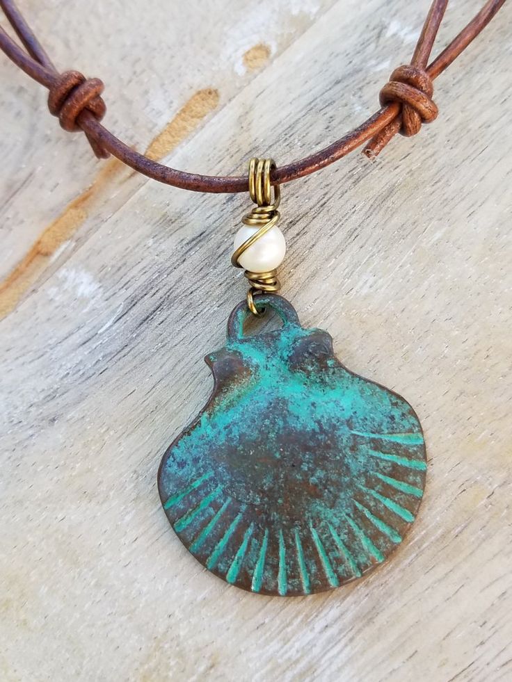 Beach Chic Scallop Shell Necklace made with an antiqued verdigris finish pendant from Mykonos, Greece, strung on adjustable leather cord and wire wrapped in antique bronze color metal. Custom orders are available using the same pendant, just shoot us a message to discuss your preferences. Handmade to order. The necklace is adjustable from 15" to a length of approximately 30". © All artwork, jewelry designs, and digital images are the property of Summer Indigo and may not be copied or reproduced Adjustable Bronze Patina Necklaces, Adjustable Brass Necklace With Patina, Metal Art Jewelry, Copper Wire Jewelry, Shell Crafts Diy, Beaded Necklace Diy, Scallop Shell, Boho Chic Jewelry, Mykonos Greece