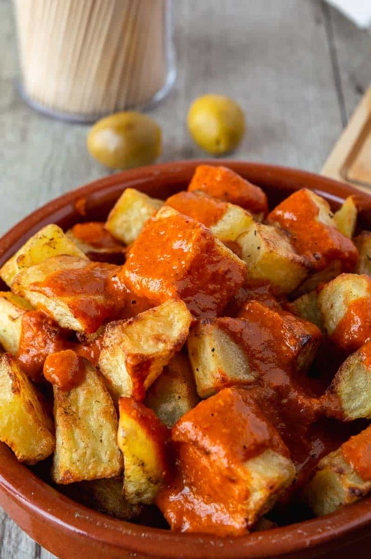 a bowl filled with cooked potatoes covered in sauce