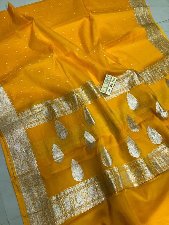 Exclusive Pure Chiffon Georgette Banarasi silk Saree With floral zari work pattern.PRODUCT DETAILSAuction For: 1 Saree with Blouse PieceColor: As shown in the pictureCondition: NewWork: FloralSaree length : 5.5 metersBlouse length : 0.8 metersWashing Instructions: Dry Clean OnlyOccasions: Wedding Wear, Party Wear, Festive Wear, Durga Puja, Indian Wear, Sangeet Wear, Bridal Wear, Chrismas Day, Mothers Day, Haldi Wear.Fall and Pico: On request (Please contact for fall and piku work)Blouse stitchin Chanderi Traditional Drape Blouse Piece For Celebration, Yellow Silk Blouse Piece, Transitional Yellow Silk Blouse Piece, Gold Georgette Blouse Piece With Zari Weaving, Silk Yellow Blouse Piece With Cutdana, Handloom Yellow Chanderi Blouse Piece, Gold Unstitched Georgette Saree, Unstitched Gold Georgette Saree, Gold Georgette Unstitched Saree