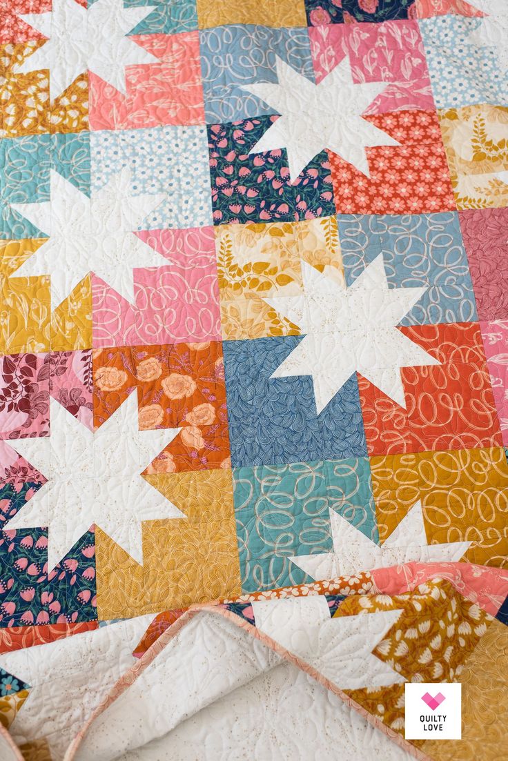 a colorful quilt with white stars on it