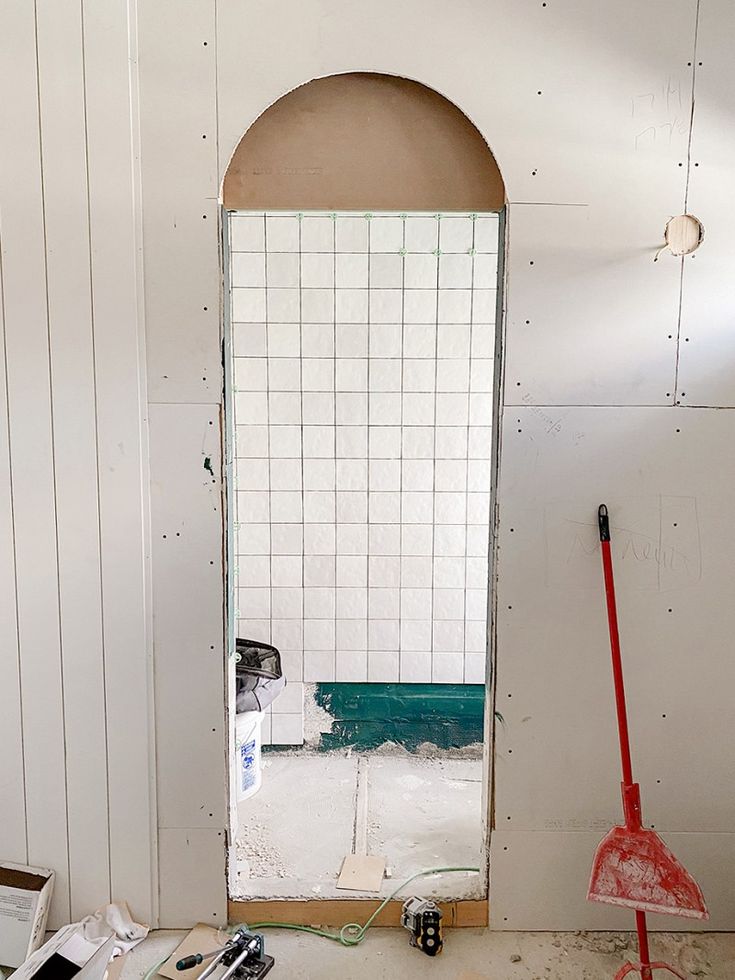 a room that is being remodeled with tools on the floor and in front of a mirror