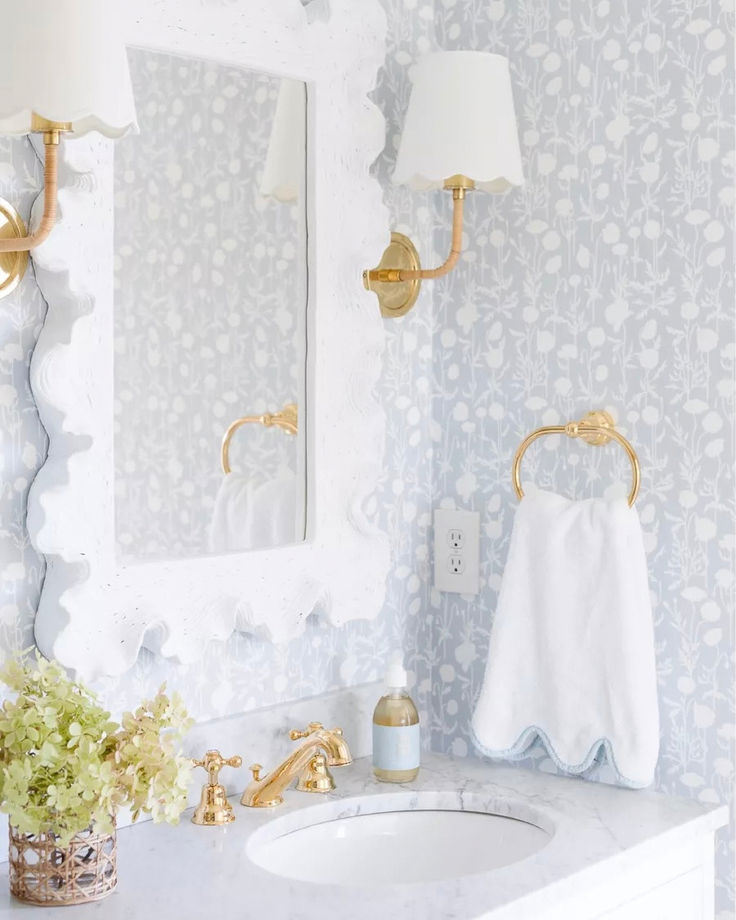 a white bathroom with blue and gold wallpaper