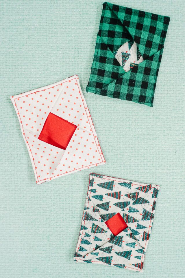 three square pieces of fabric on top of each other, one with an origami piece in the middle