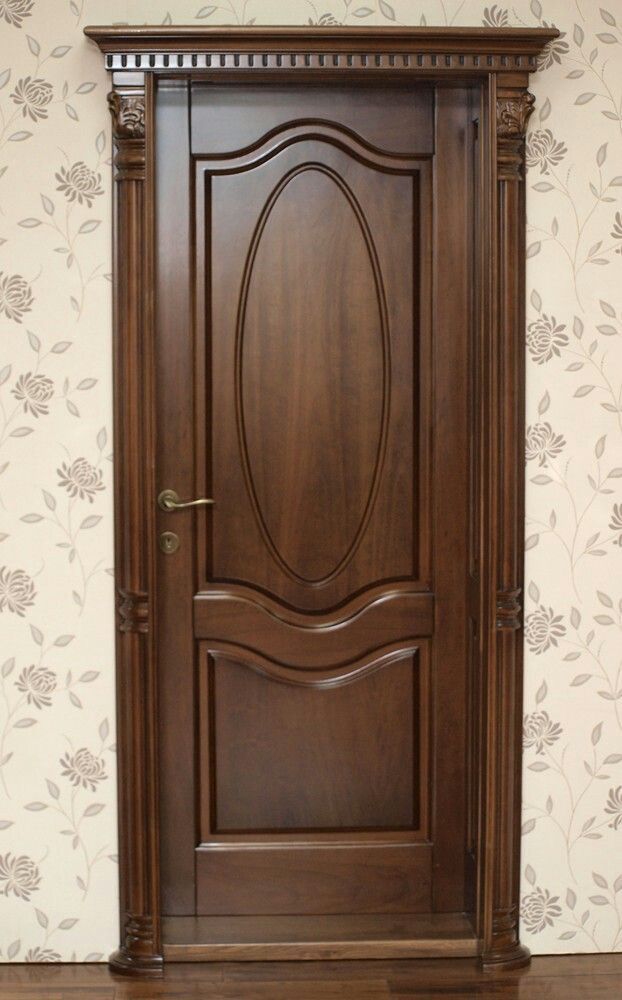 a wooden door in front of a floral wallpaper