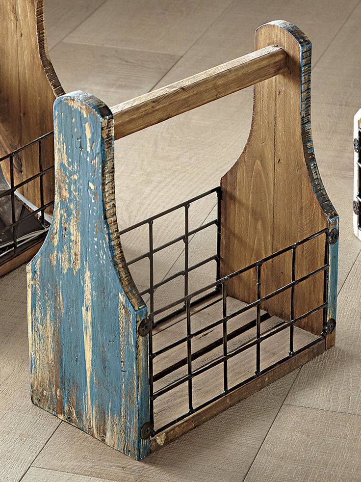 an old wooden chair sitting on top of a hard wood floor next to a metal basket