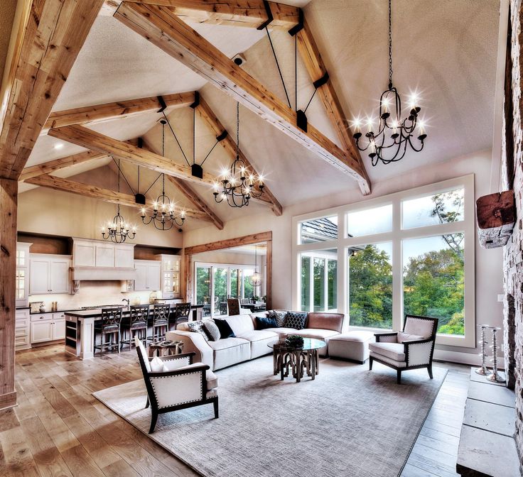 a large living room filled with furniture and a chandelier hanging from the ceiling