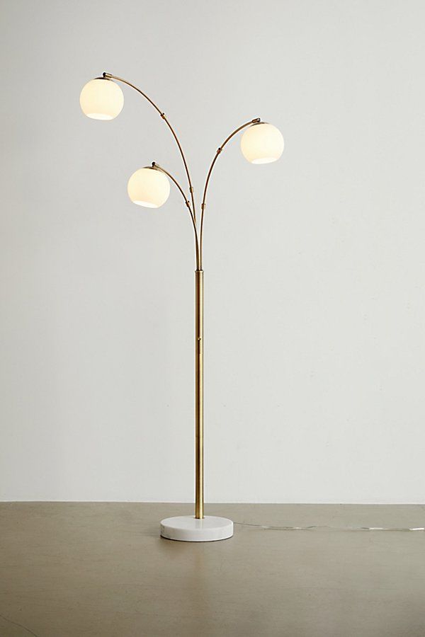 a floor lamp with three lights on top of it and a round base in the middle