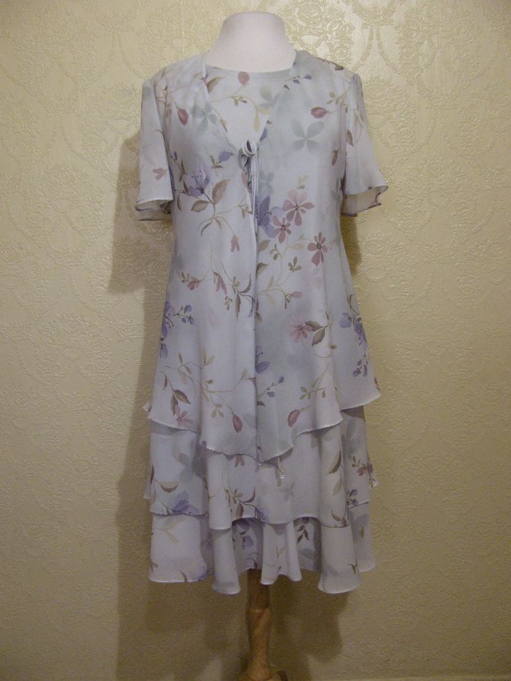 This is a very pretty 2 piece sleeveless long layered dress with matching long sheer chiffon jacket by r&m richards. still in brand new condition. it is a size 8. please go by the measurements below for proper fit. very elegant pretty women look. perfect for a garden party or summer wedding. the dress has a modest scoop neckline with a small keyhole button back. the dress is made of a pastel light sage green floral print crepe chiffon. the flowers are very light pastels of pinks and periwink Spring Short Sleeve Dress With Overlay, Spring Dress With Short Sleeves And Overlay, Spring Dresses With Overlay And Short Sleeves, Flowy Spring Dress With Overlay, Summer Flowy Dress For Mother Of The Bride, Fitted Summer Dress With Overlay, Spring Knee-length Dress For Mother Of The Bride, Knee-length Spring Dress For Mother Of The Bride, Spring Formal Dress With Overlay