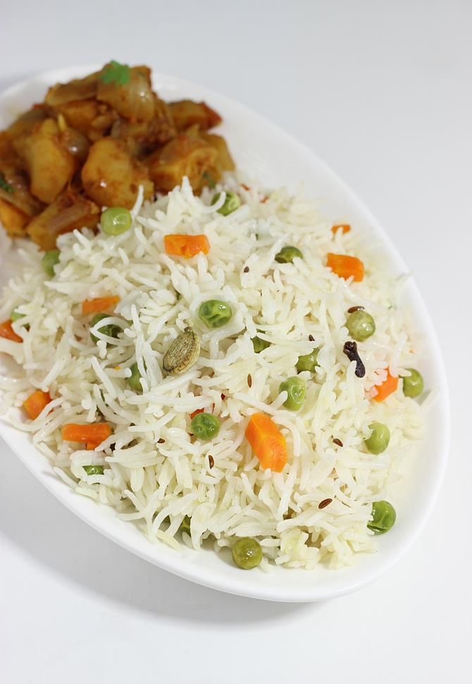 a white plate topped with rice and vegetables