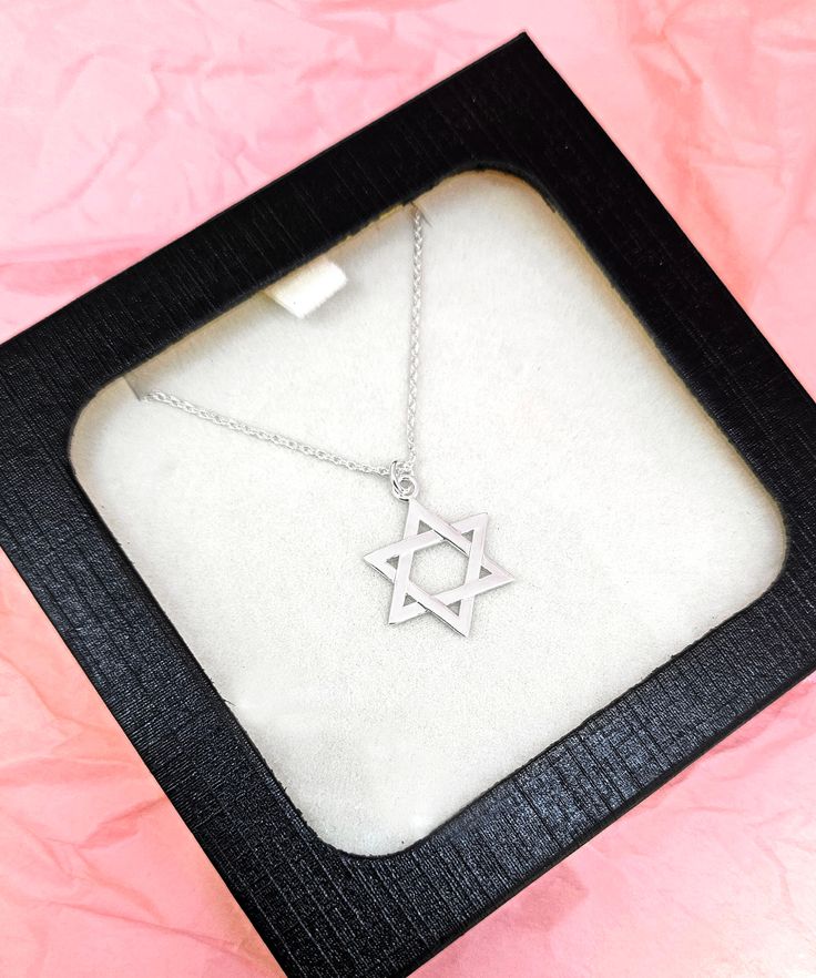 Beautifully crafted Star Of David Necklace. Add this symbolic piece to your collection or get it a as gift. This .75" Star of David pendant delicately hangs from a 16" inch chain with a convenient 2" extension and lobster claw closure. Made of premium quality, outstanding craftsmanship. Available in Gold and Silver. Take advantage of our Bulk discount! 6 Necklaces - 30% Off ($14 each) 12 Necklaces - 50% Off ($10 each) Sterling Silver Symbolic Necklace With Star Charm, Symbolic Sterling Silver Star Charm Necklace, Star Of David Charm Jewelry Gift, Silver Star Necklace For Mother's Day, Spiritual Jewelry With Star Charm For Gift, Symbolic Star-shaped Jewelry As Gift, Star Charm Pendant Jewelry Gift, Spiritual Star Charm Jewelry For Gifts, Spiritual Star-shaped Jewelry For Gifts