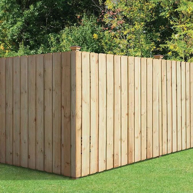 a wooden fence in the middle of some grass