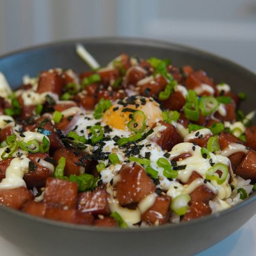 a close up of a bowl of food with meat and vegetables in it on a table