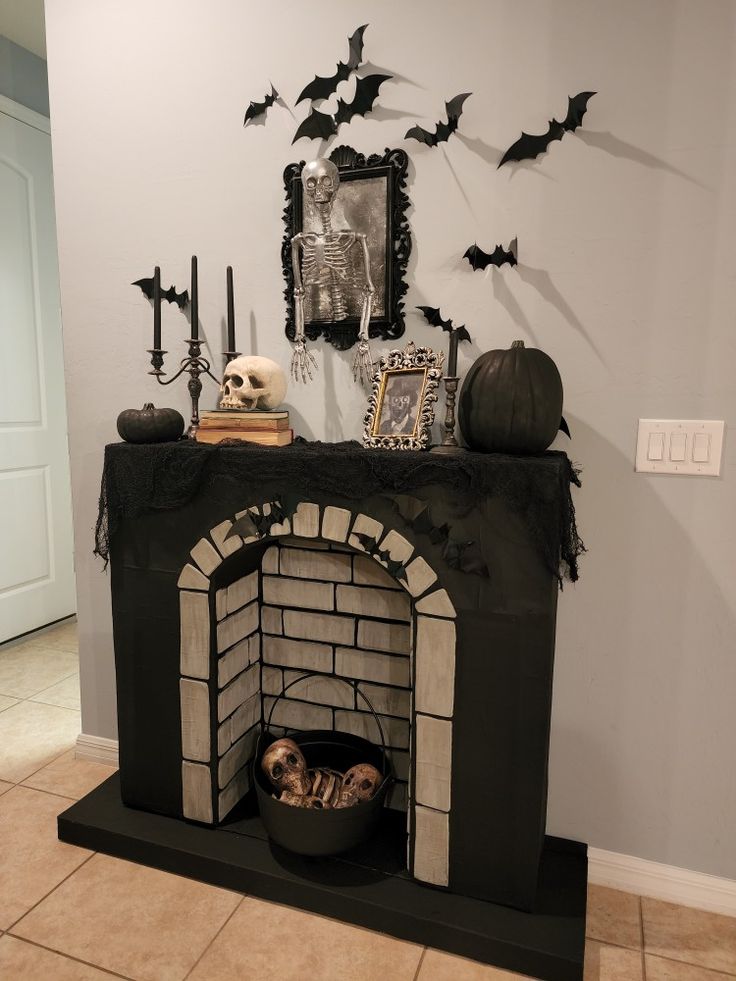 a fireplace decorated for halloween with bats and skulls