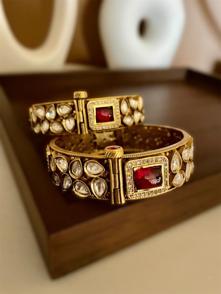 Kundan openable kada bracelet in Antique gold finish with ruby red stones. Rajwadi kada with premium quality gold foiled kundan from our Indian wedding collections. Create beautiful memory for any occasion with elegant jewelry for your loved ones You will receive carefully packaged items in jewelry box, ready to give memorable gift  to your Wife, mother, sister  friend or collegue. All orders will be shipped  out in 1 business day after receiving order. Plz do ensure correct address at checkout. Luxury Kundan Bangle For Ceremonial Occasions, Luxury Festive Bangle With Intricate Design, Traditional Ruby Bangle For Festive Occasions, Traditional Gold Bangle With Ruby, Red Heavy Temple Jewelry Bangle, Traditional Gold Ruby Bangle, Heavy Red Temple Jewelry Bangle, Ceremonial Red Bracelets With Hand Set Details, Ceremonial Red Hand Set Bracelets