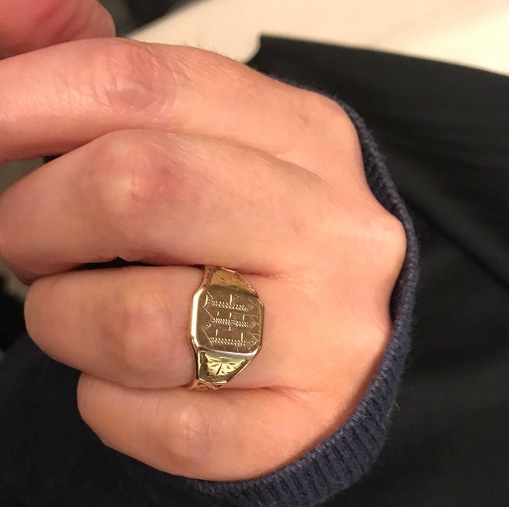 a close up of a person wearing a ring on their finger and holding something in his hand