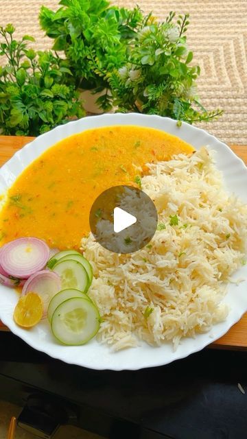 a white plate topped with rice and veggies next to a bowl of soup