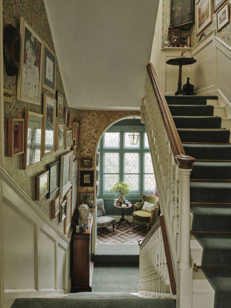 a staircase leading to a living room with pictures on the wall