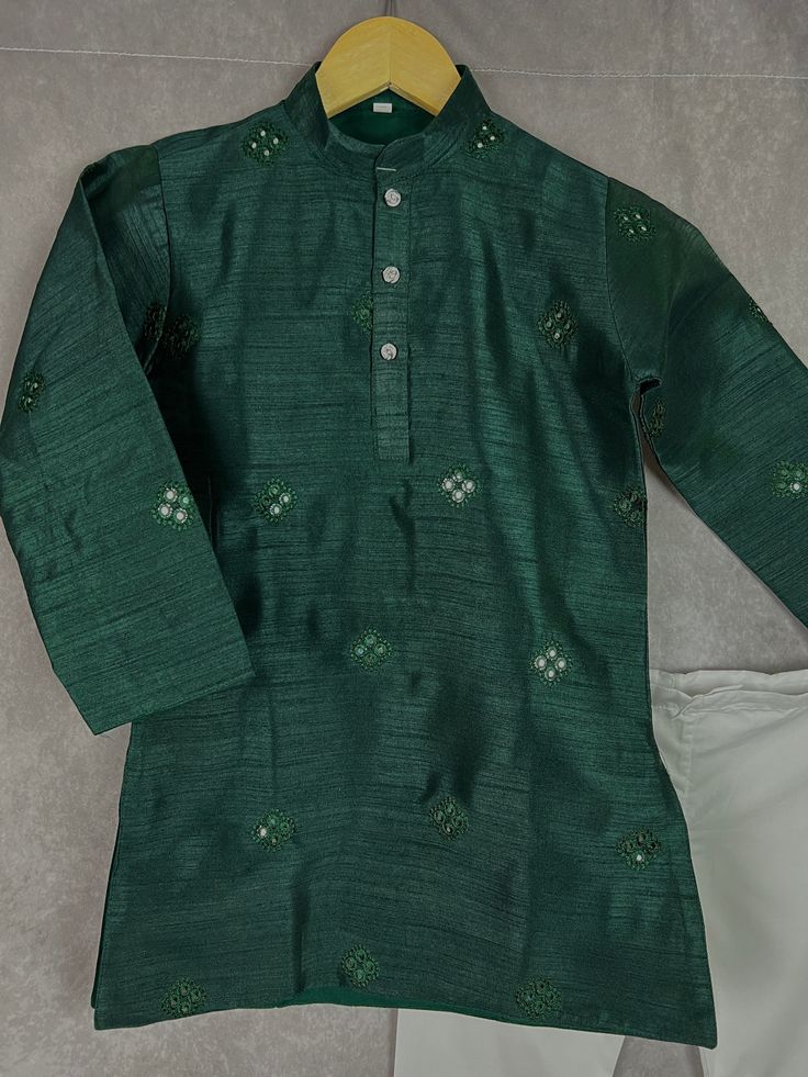 Boys Kurta Pajama Set in Soft Raw Silk Material with Cotton Pajama. The Kurta comes with embroidery and artificial mirror work. It has soft Cotton Lining. Item : Boys Kurta Pajama Ready to Wear : Yes Kurta Color : Bottle Green Pajama Color : White (Cotton) Fabric : Soft Raw Silk Pocket : Yes Lining (Yes/no) : Yes, a very soft cotton lining is attached with the Kurta. Disclaimer - There can be little variation in the color due to screen resolution setting, phone display setting or anything else. Semi-stitched Embroidered Green Kurta, Navratri Raw Silk Sets With Zari Work, Dola Silk Straight Kurta Set With Resham Embroidery, Resham Embroidery Dola Silk Straight Kurta Set, Dola Silk Sets With Resham Embroidery, Straight Kurta Style, Pista Green Dola Silk Sets With Resham Embroidery, Raw Silk Sets With Resham Embroidery For Eid, Resham Embroidery Raw Silk Sets For Eid, Festive Dola Silk Sets With Multicolor Embroidery