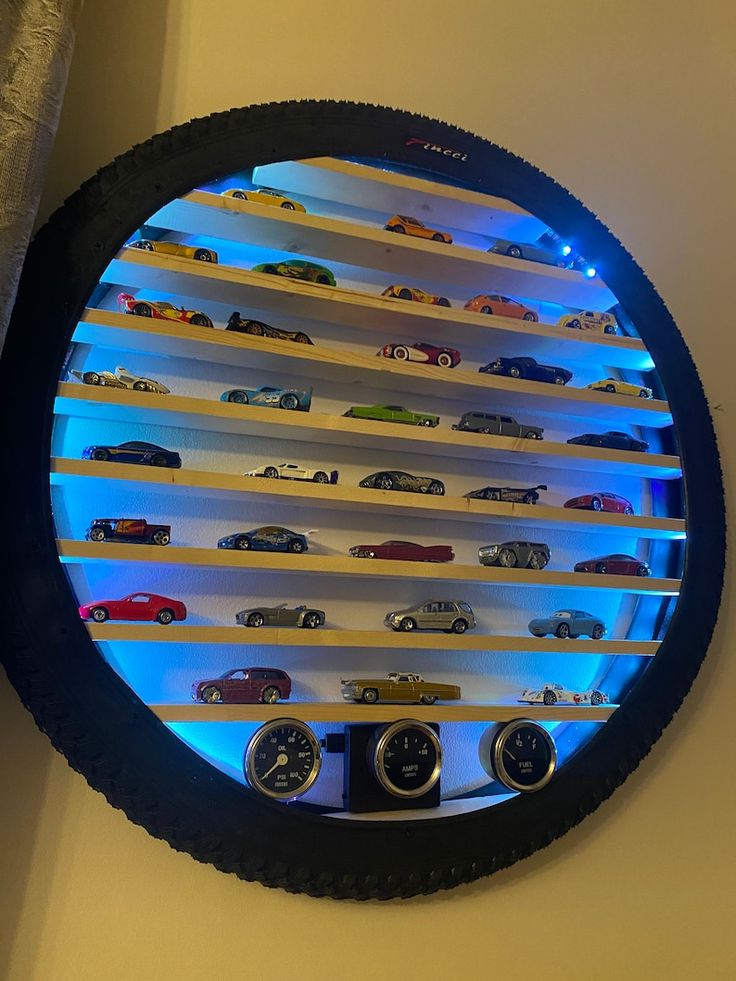 there is a clock that has many cars on display in the glass case behind it