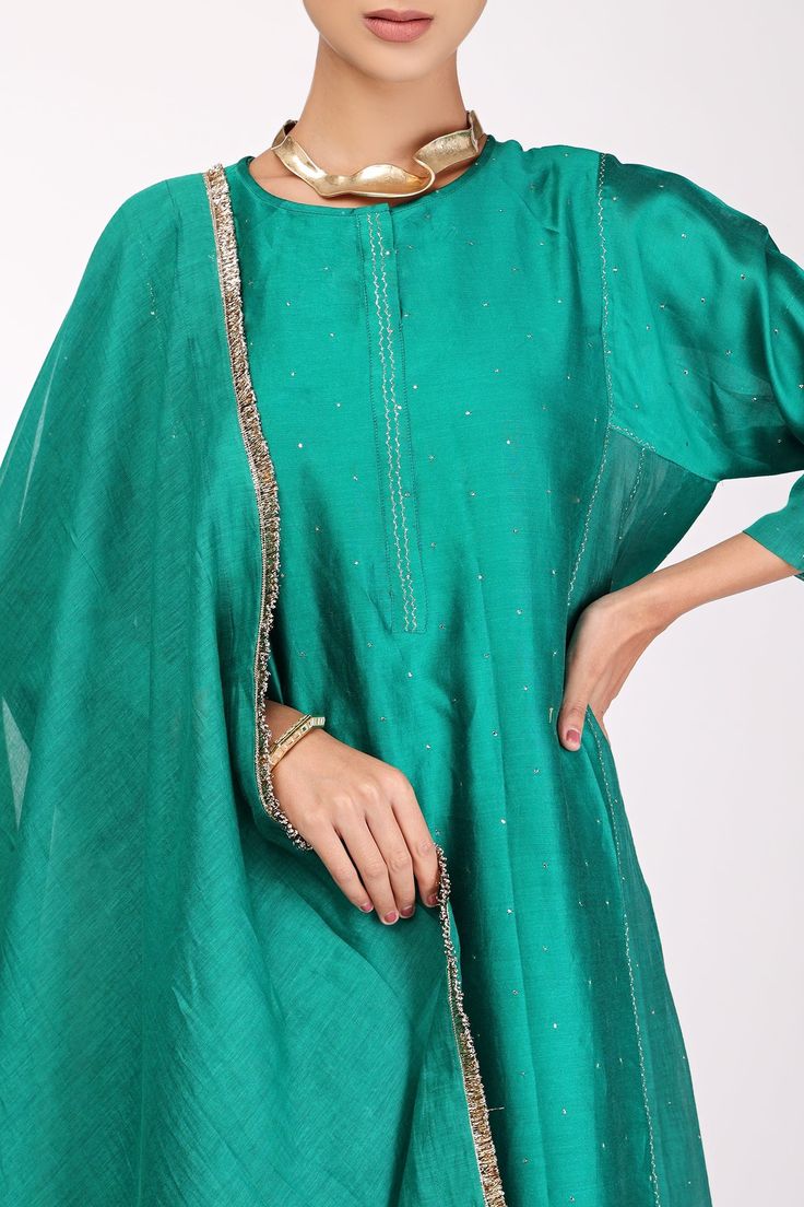 Rama green chanderi kalidar kurta with mukaish hand and zari machine embroidery. Comes with pant and a dupatta.
Component: 3
Pattern: Embroidered
Type Of Work: Mukaish, Zari
Neckline: Round
Sleeve Type: Full
Fabric: Chanderi, Lining : Cotton
Color: Green
Other Details: 
Note : Necklace worn by the model is not for sale.
Occasion: Puja - Aza Fashions Festive Tussar Silk Palazzo Set For Eid, Eid Festive Tussar Silk Palazzo Set, Festive Eid Tussar Silk Palazzo Set, Designer Chanderi Kurta With Dabka Work, Transitional Chanderi Kurta With Zari Work, Pista Green Chanderi Kurta With Dabka Work, Festive Dola Silk Kurta With Gota Work, Eid Chanderi Kurta With Dabka Work, Eid Raw Silk Kurta With Gota Work