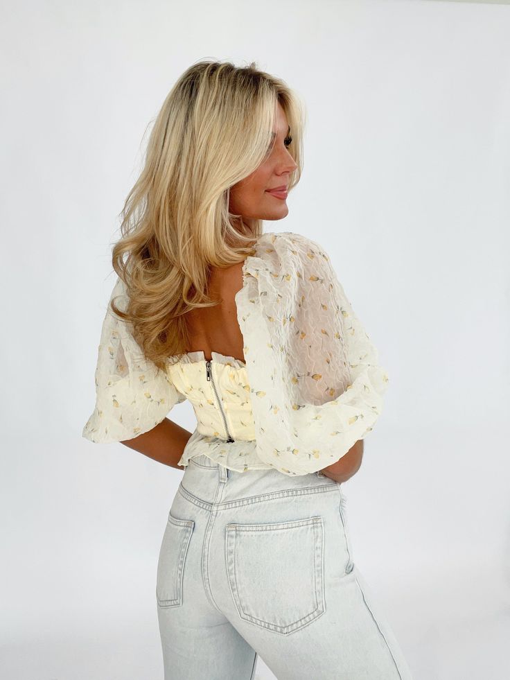 Indulge in effortless femininity with our puff sleeve sheer top. Featuring a sweetheart neckline, ruffled puff sleeves, and a cropped, floral design, this piece exudes elegance. The sheer overlay adds a touch of allure, while the soft inner lining ensures maximum comfort. Finished with a back zipper closure for a seamless fit, this top is perfect for adding a pop of bright color to your summer wardrobe. Make a statement on date night or soak up the sunshine in style. Self 100% Polyester Lining 1 Elegant Summer Crop Top With Sheer Sleeves, Chic Puff Sleeve Crop Top For Spring, Elegant Spring Crop Top With Sheer Sleeves, Chic Crop Top With Sheer Sleeves For Summer, Chic Summer Crop Top With Sheer Sleeves, Fitted Crop Top With Lantern Sleeves For Spring, Fitted Lantern Sleeve Crop Top For Spring, Elegant Sheer Sleeves Crop Top For Spring, Feminine Fitted Puff Sleeve Top With Balloon Sleeves