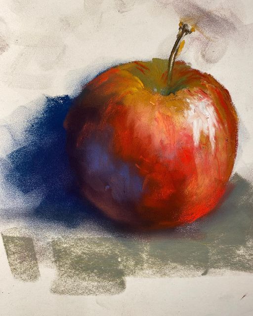 an apple sitting on top of a white surface