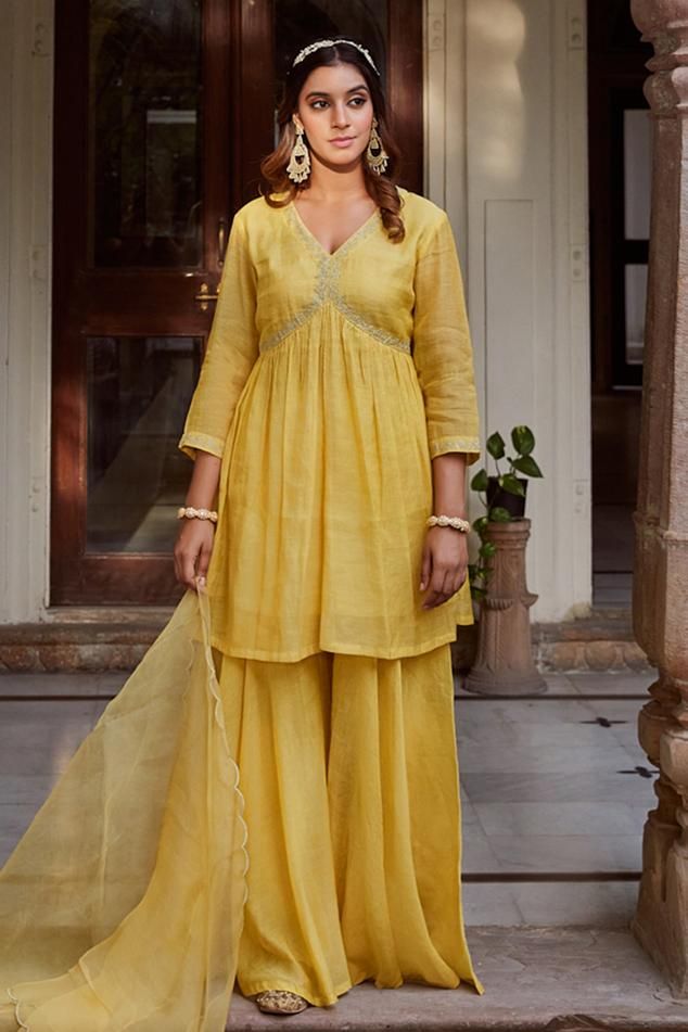 Yellow kurta with floral aari, sequin embroidery, gathers detailing and side slits. Paired with gharara and embroidered dupatta.
Components: 3
Pattern: Embroidered
Type Of Work: Floral
Neckline: Round
Sleeve Type: Half
Fabric: Chanderi tissue
Color: Yellow
Other Details: 
Side slits
Scallop border dupatta
Length:
Kurta: 32 inches
Gharara: 42 inches
Dupatta L x W : 2.5 mtrs x 34 inches
Occasion: Puja - Aza Fashions Yellow Kurta, Scallop Border, Types Of Work, Sequin Embroidery, Embroidered Dupatta, Sequins Embroidery, Set For Women, Aza Fashion, Sleeve Type