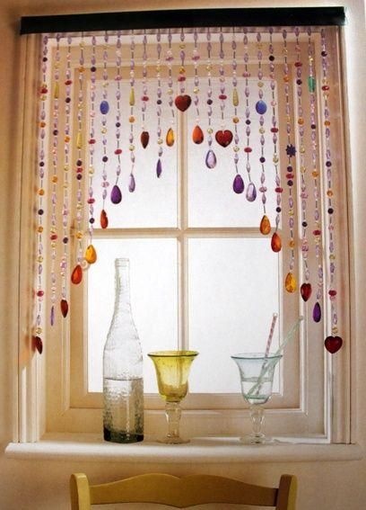 a window with beads hanging from it's side and two vases on the windowsill