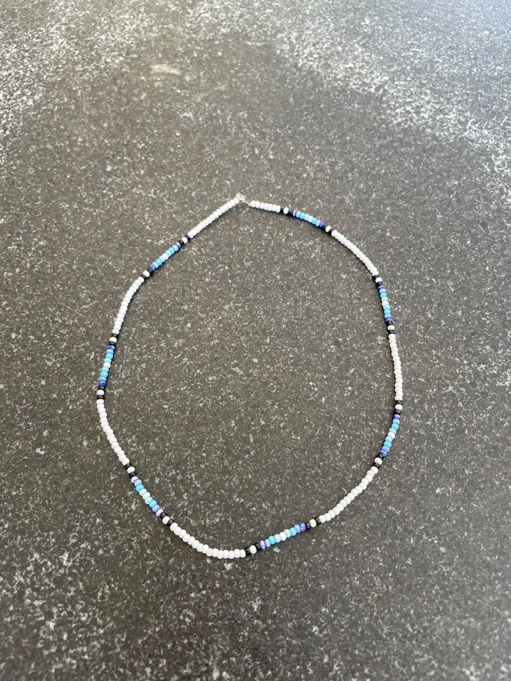 a blue and white beaded bracelet sitting on top of a table