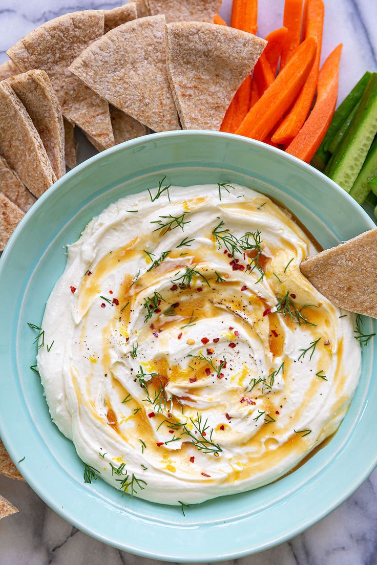 hummus, carrots and crackers on a plate