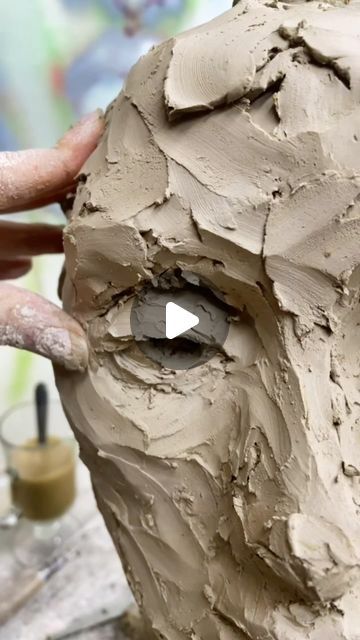 a person is making a clay face with their fingers and thumb on the top of it