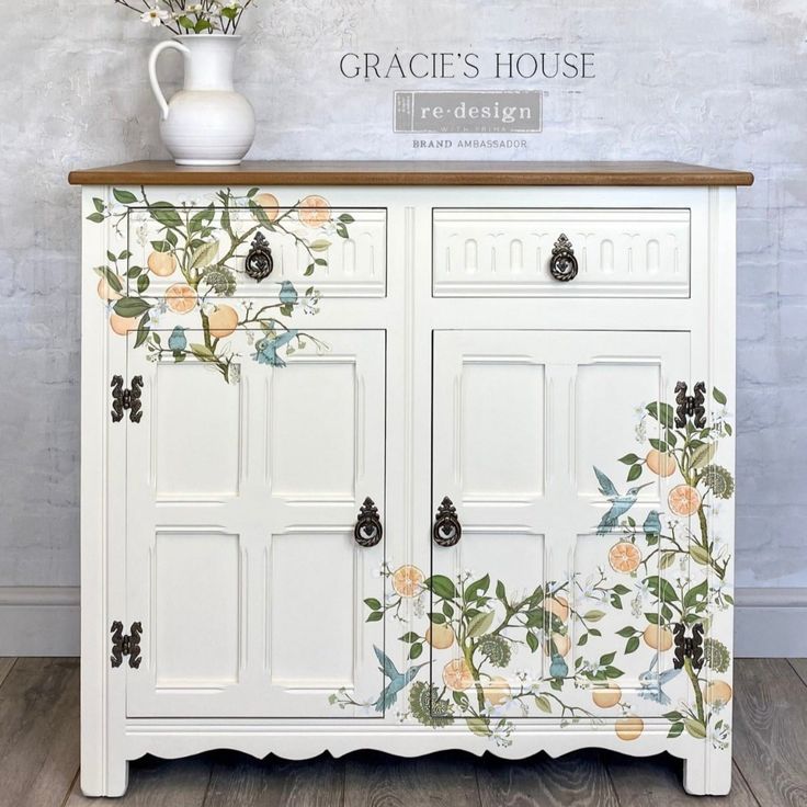 a white cabinet with flowers painted on it