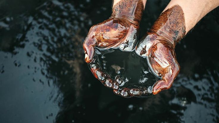 two hands holding something that looks like it is covered in mud and water, while the other hand holds an object