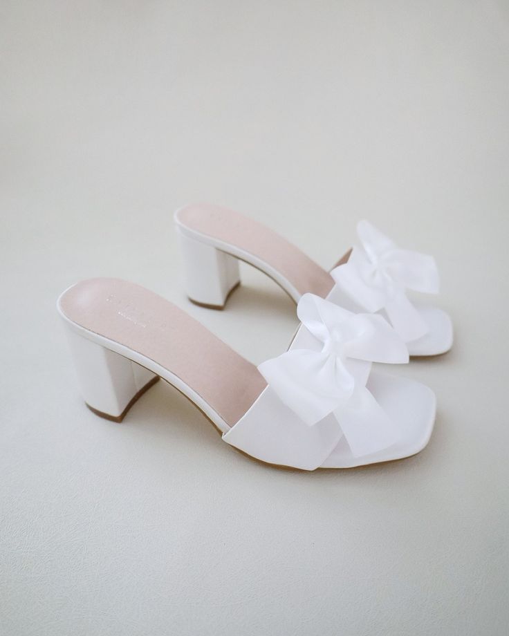 "Classic satin slip on block heel sandals for casual and dressy look. Style with satin bow at the front that adds a romantic touch, or without the bow for a classy simple style. Comfortable and easy wear for bridal wear, bridesmaids, holiday party, wedding parties, and any special occasions.  DETAILS: HEEL HEIGHT: 2.5 Inches COLORS AVAILABLE: Ivory and White UPPER: Synthetic upper and lining MATERIALS: Manmade outsole STYLE NAME: VERONA Not sure of which size to purchase? Shoes measurements are Bridesmaids Sandals, Block Heels Wedding, Bridesmaid Sandals, Sandals With Bow, Sandals Wedding, Pretty Sandals, Short Heels, Bridal Sandals, Cute Heels