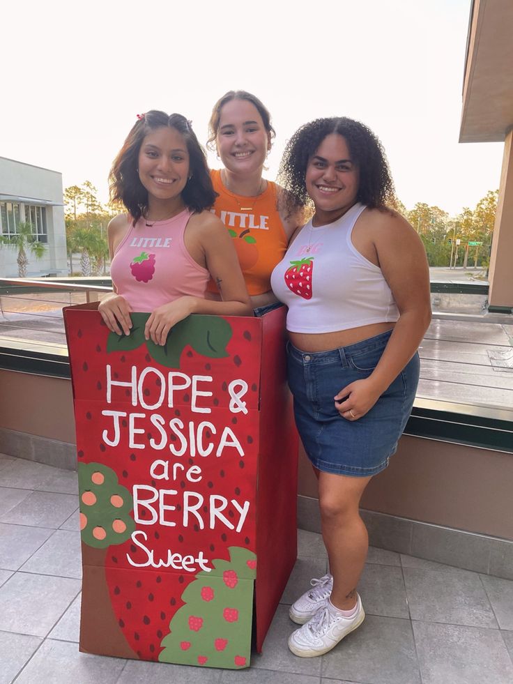 three girls are standing next to a sign that says hope and jesus are berry sweet