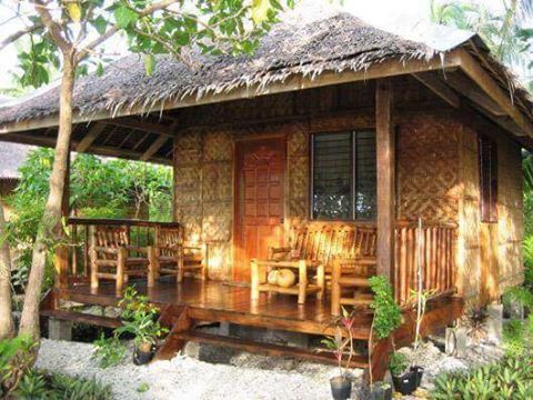 a small wooden house sitting on top of a lush green hillside