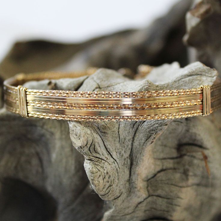 "A stylish and eye-catching bracelet, handcrafted with ten strands of 14kt gold filled wire in a classic wire-wrap style. Six strands of twist wire, two on each side and two in the middle, spaced with four strands of plain square wire, two on each side of the middle. Dress it up or down--it's definitely a wear-with everything accessory! And stackable with so many of my other bracelet styles. There's nothing like an armful of affordable gorgeousness! The built-in hook and eye-type clasp is easy t Adjustable Heirloom Gold Bangle Bracelet, Adjustable Heirloom Jubilee Bracelet, Adjustable Heirloom Style Gold Jubilee Bracelet, Adjustable Heirloom Gold Jubilee Bracelet, Heirloom Adjustable Gold Jubilee Bracelet, Handmade Double Band Bracelet As Gift, Heirloom Adjustable Cuff Bangle Bracelet, Heirloom Style Handmade Bracelet For Gift, Artisan Wire Wrapped Bracelets