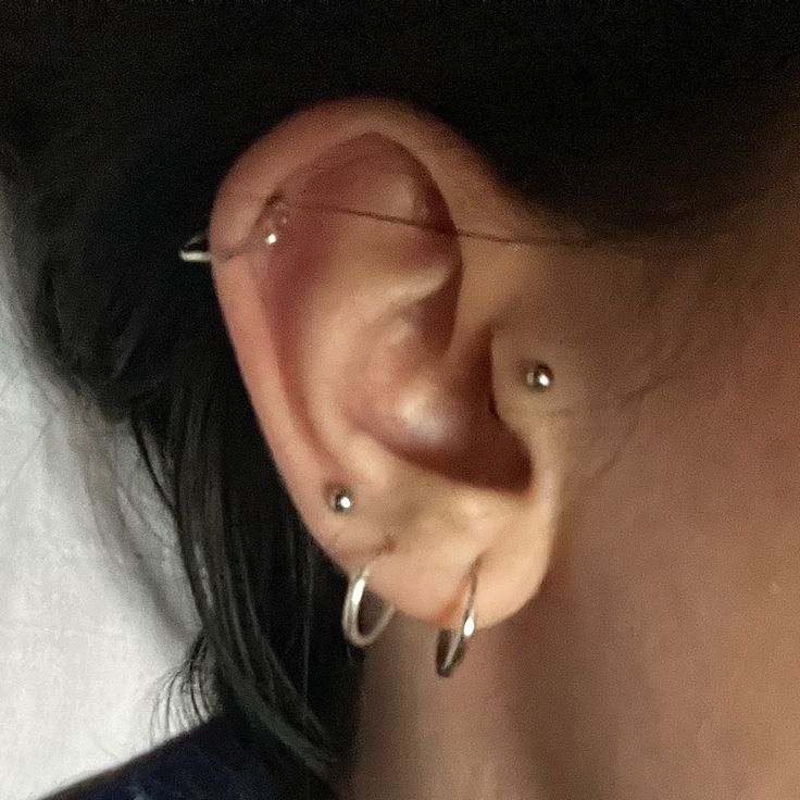 a close up of a person's ear with two piercings on the side