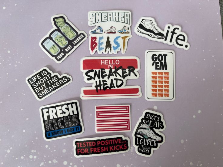 a bunch of stickers that are on top of a purple surface with white and black writing