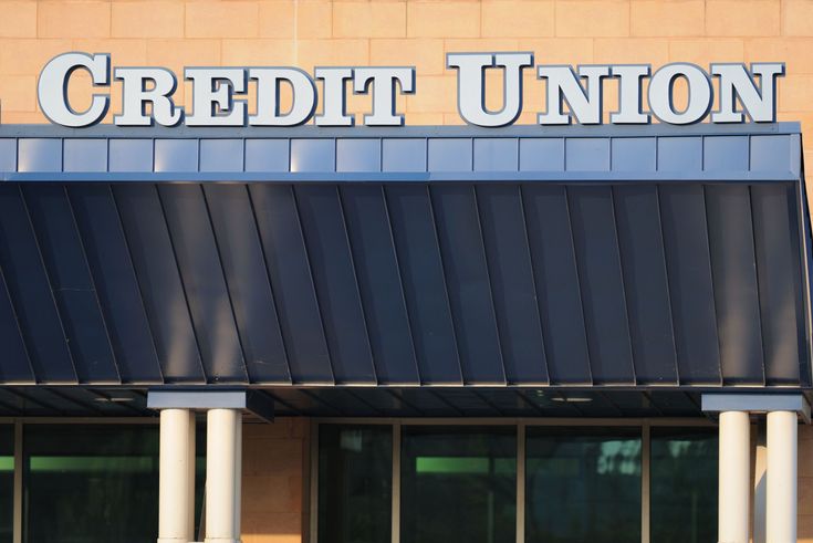 the front of a building with columns and a sign that reads credit union