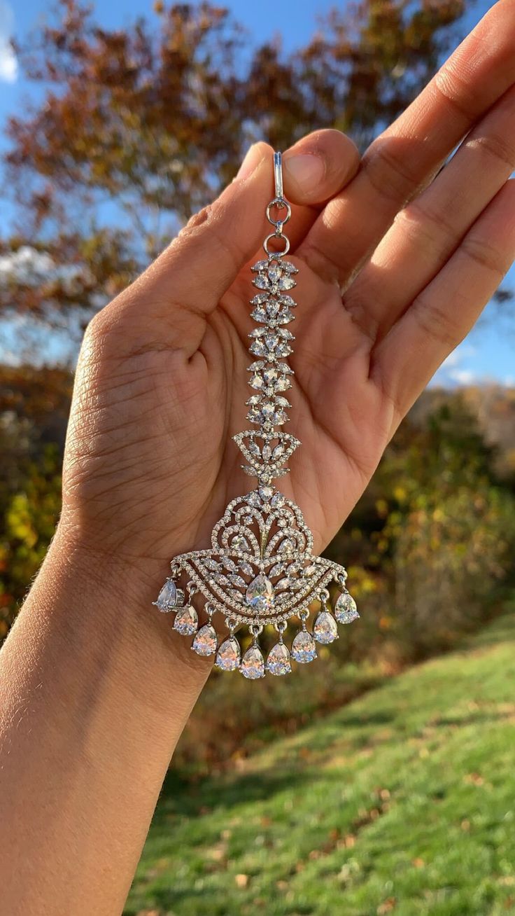 This is a very beautiful Mangtika available in transparent color and AD Diamonds. The material is first-rate brass which will not tarnish as it does not contain real silver. We use the best materials and provide the best workmanship for our customers! Pair it with any western or traditional outfit. Ready to ship from our home to yours! Silver Jeweled Chandbali Jewelry, Ornate Silver Kundan Jewelry, Bollywood Style Jeweled Tikka As Gift, Traditional Silver Jeweled Jewelry, Elegant Silver Tikka For Festivals, Elegant Silver Tikka For Festive Occasions, Silver Jeweled Jewelry For Festivals, Traditional Bling Jewelry For Wedding, Traditional Silver Tikka As Gift