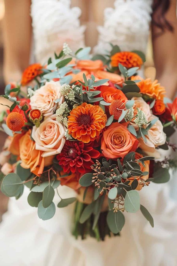 a bridal bouquet with orange and red flowers