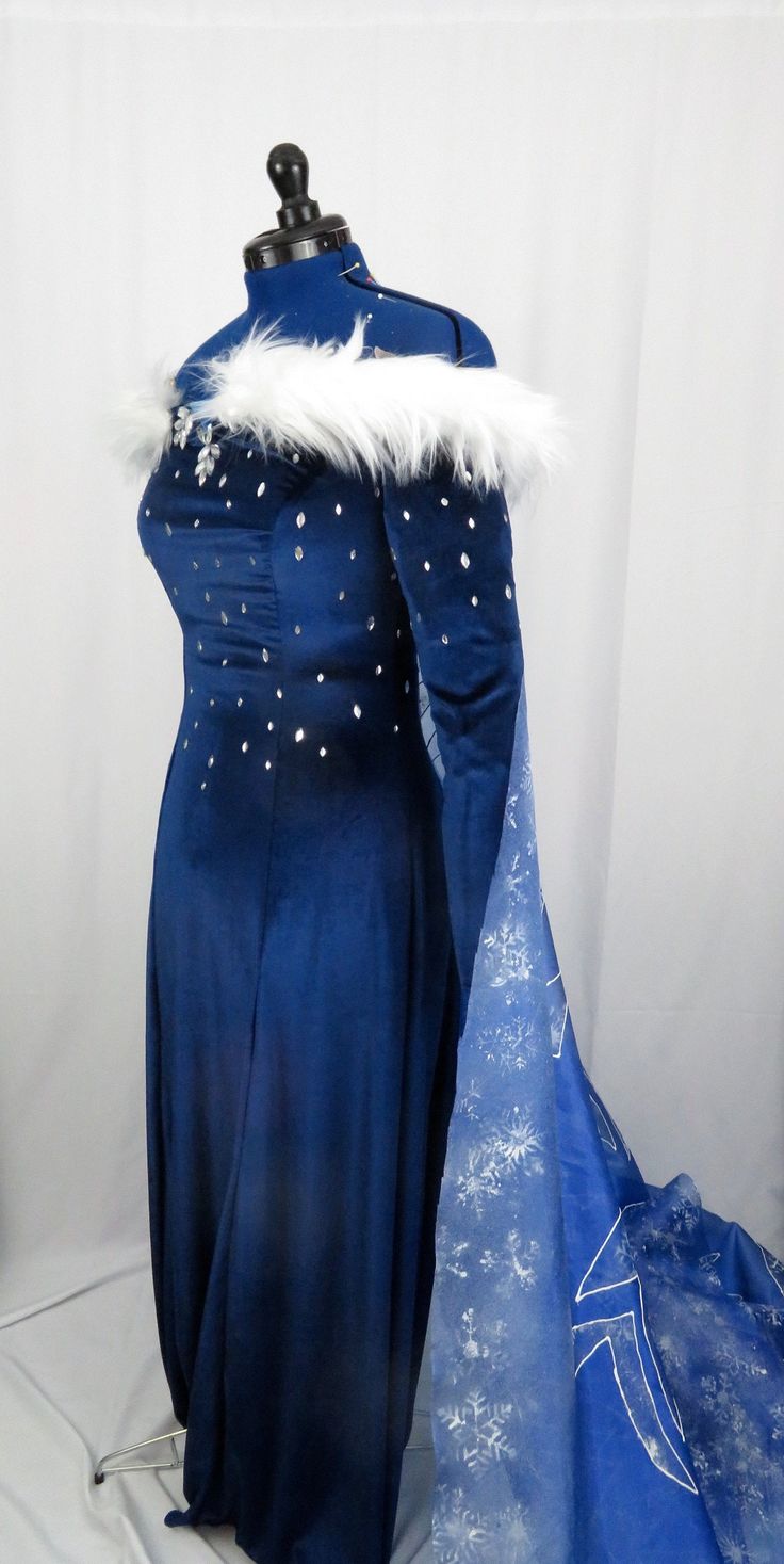 This is for a custom made gown inspired by the new frozen short for Elsa the Snow Queen. The dress is made out of a nice blue stretch velvet. The cape is made out of organza and hand painted. The cape is detachable with snaps. Dress zips in the back. The dress is unlined. It is custom made, so if there are any changes you would like, message me and we can discuss it! Measurements needed: Bust, Bra, waist, hips, height, shoulder to floor (include shoes if you want the gown hemmed to the height wi Winter Blue Dress, Queen Dress Gowns, Ice Queen Dress, Snow Queen Dress, Daenerys Targaryen Dress, Gala Attire, Frozen Cosplay, Gown Costume, Frozen Elsa Dress