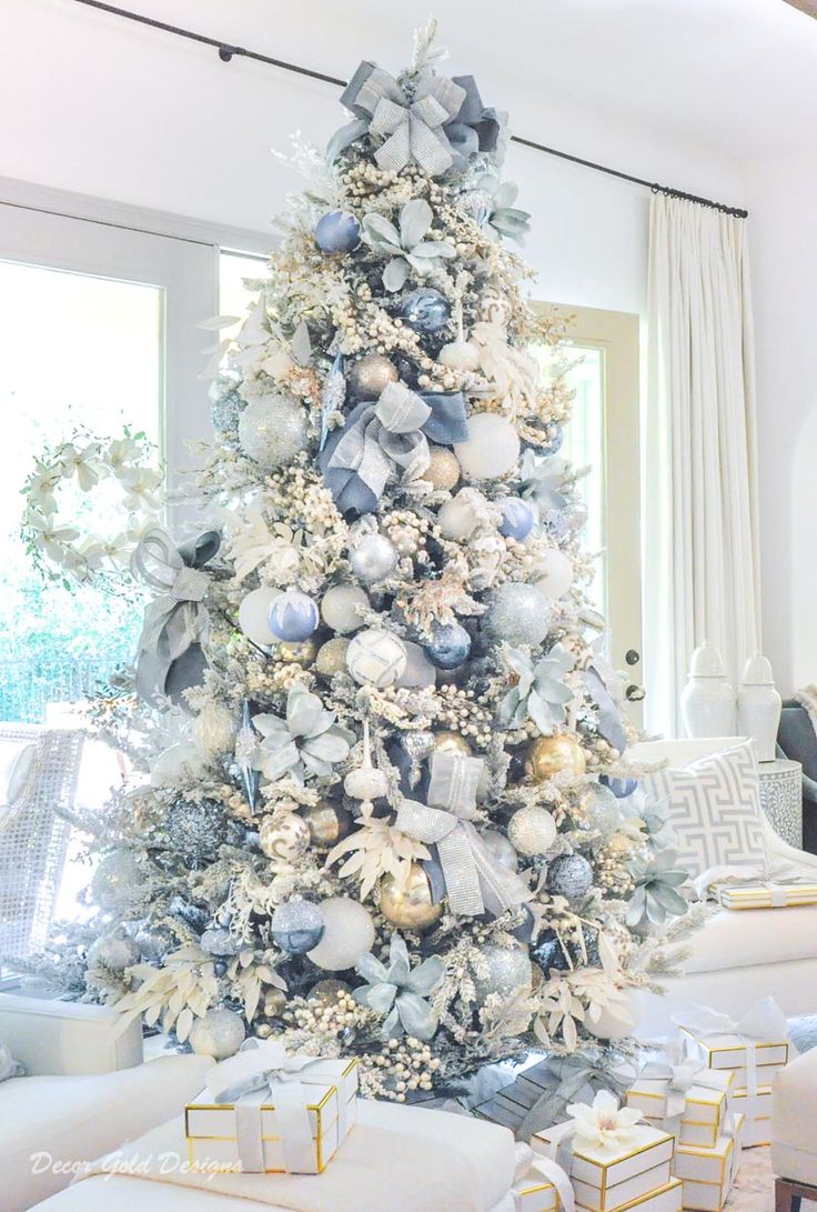 a white christmas tree decorated with silver ornaments