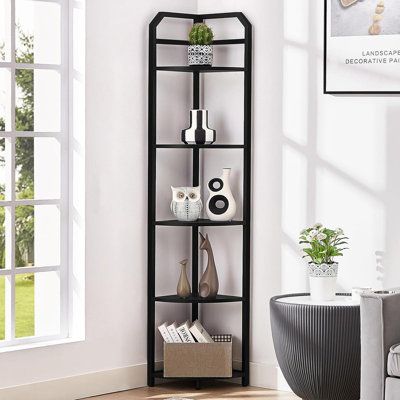 a corner shelf in the middle of a living room with white walls and wood floors