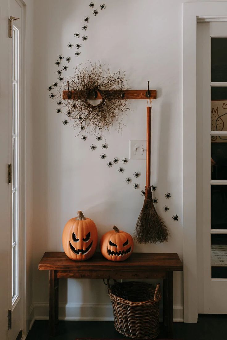 two pumpkins sitting on a wooden table in front of a white wall with black stars