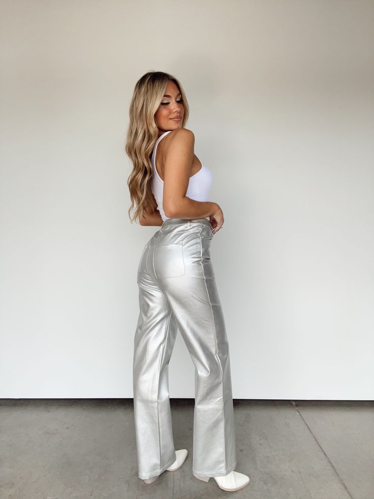 These Metallic Moment Pants deliver undeniable glamour with their elegant, elevated style. Crafted from soft and stretchy materials, they feature a chic high waisted fit and classic button and zipper closure. Completed with pocket details and a straight leg, they are the perfect final touch for any sophisticated, yet fun, look. Shine bright in game day or night with their unique statement shine. 100% Polyester Spot clean only. Elevated Style, Final Touch, Silver Buttons, Pocket Detail, Shine Bright, Stretchy Material, Casual Pants, Straight Leg, High Waisted