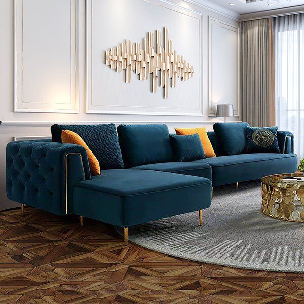 a living room with blue couches and gold accents on the walls, wood flooring